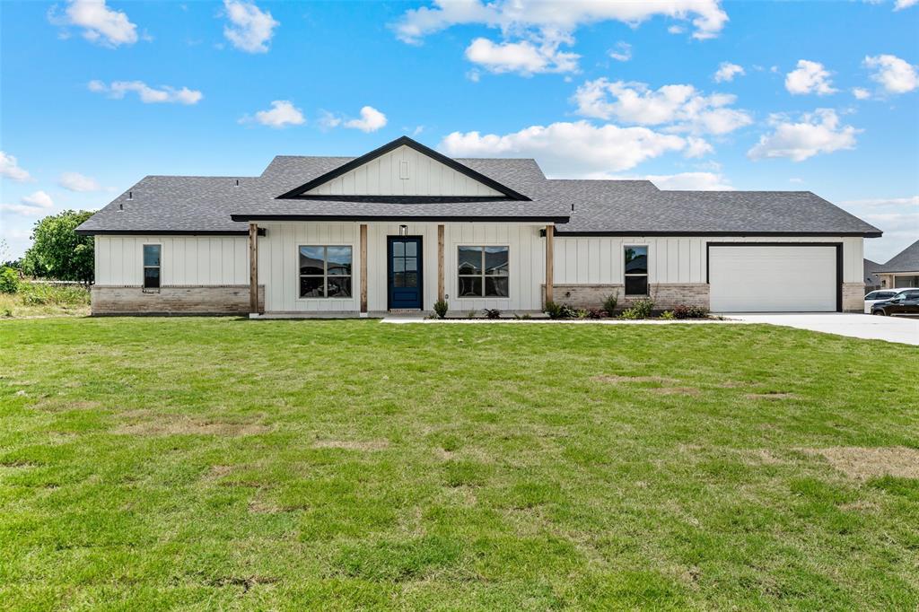 138 Dana Pt Road Lorena, TX 76655 - Photo 3 of 24 Modern farmhouse-style residence featuring white vertical siding, a dark gray asphalt shingle roof, and stone facade accents