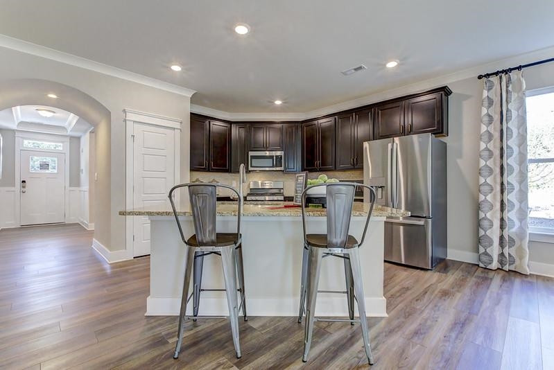1000 Heartstone Way Durham, NC 27713 - Photo 17 of 35 a kitchen with stainless steel appliances a refrigerator a stove top oven and wooden floors