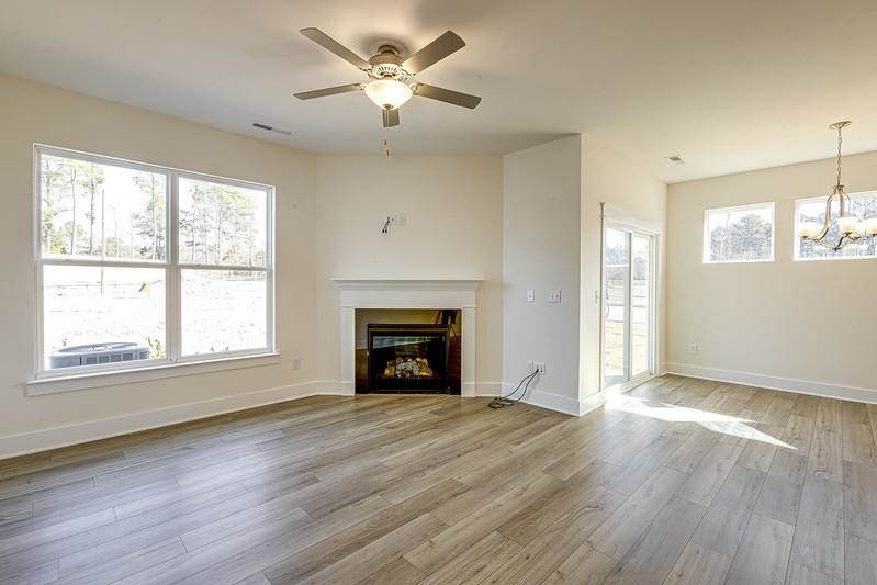 1000 Heartstone Way Durham, NC 27713 - Photo 7 of 35 an empty room with wooden floor fireplace and windows