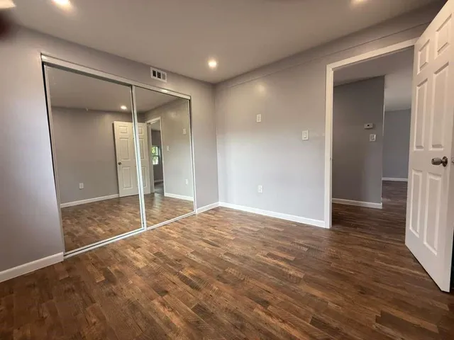 a view of empty room with wooden floor
