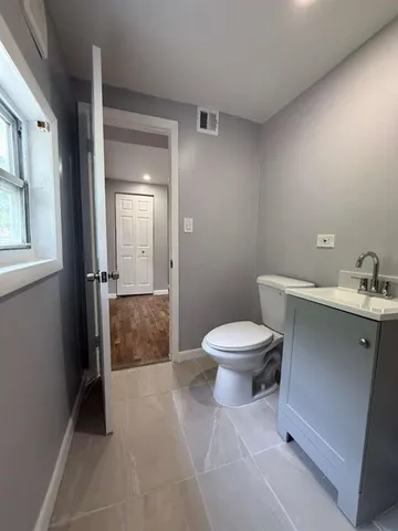 a bathroom with a toilet a sink and mirror