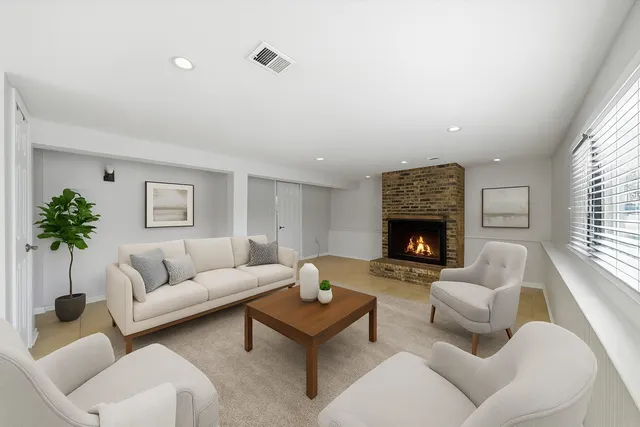 a view of an empty room with a fireplace and a window