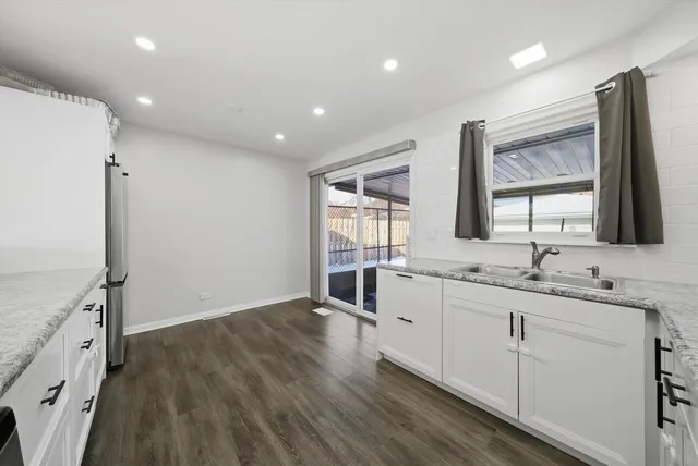 a large kitchen with lot of counter space and wooden floor