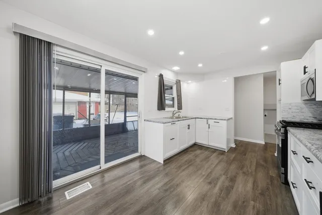 a large kitchen with stainless steel appliances kitchen island granite countertop a stove a sink and a refrigerator