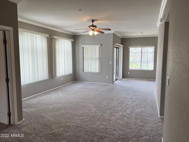 a view of a big room with windows and chandelier fan
