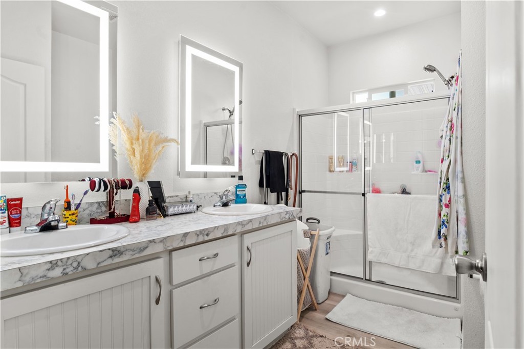 7101 Rosecrans Avenue, Unit 137 Paramount, CA 90723 - Photo 15 of 30 a bathroom with a granite countertop sink mirror and double