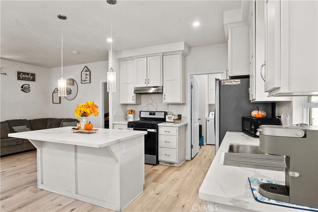 7101 Rosecrans Avenue, Unit 137 Paramount, CA 90723 - Photo 5 of 30 a kitchen with white cabinets and stainless steel appliances