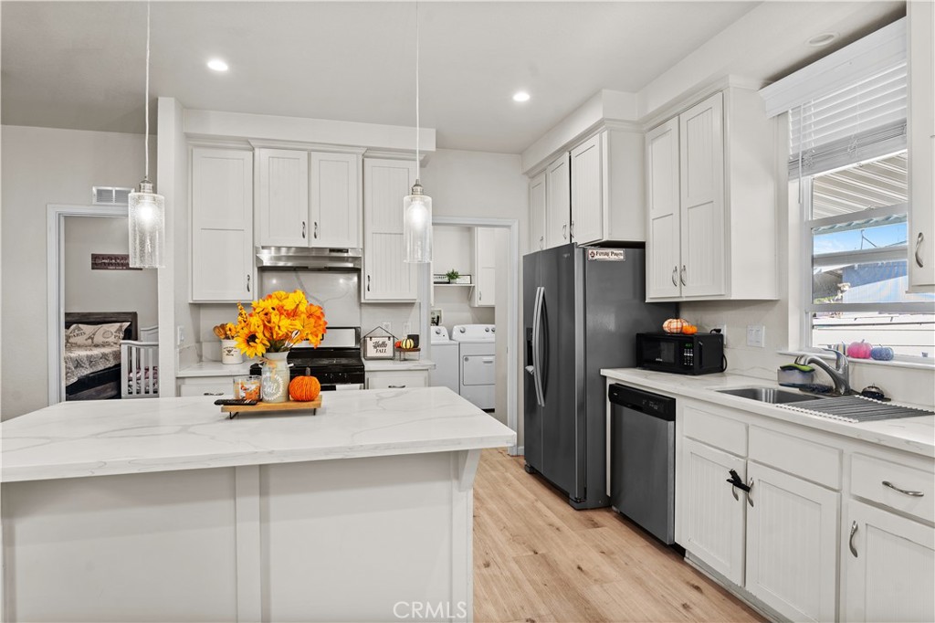 7101 Rosecrans Avenue, Unit 137 Paramount, CA 90723 - Photo 8 of 30 a kitchen with a sink cabinets and refrigerator