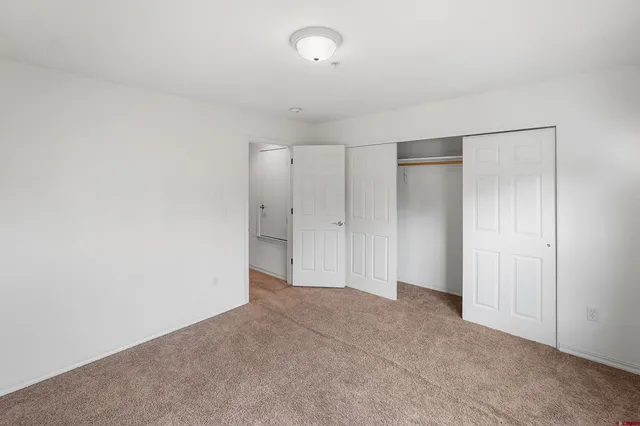 a view of a hallway with closet and wooden floor