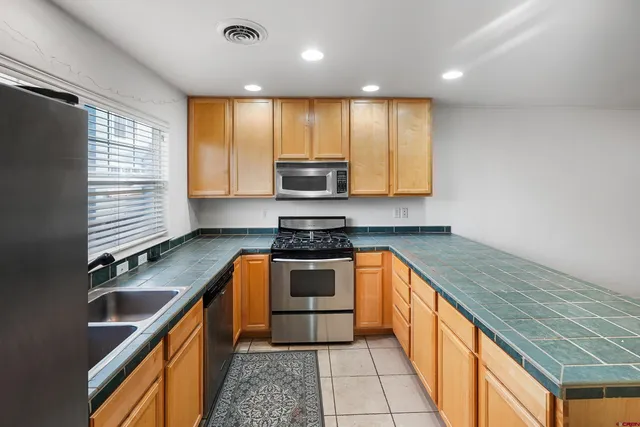 a kitchen with stainless steel appliances granite countertop a refrigerator and a sink