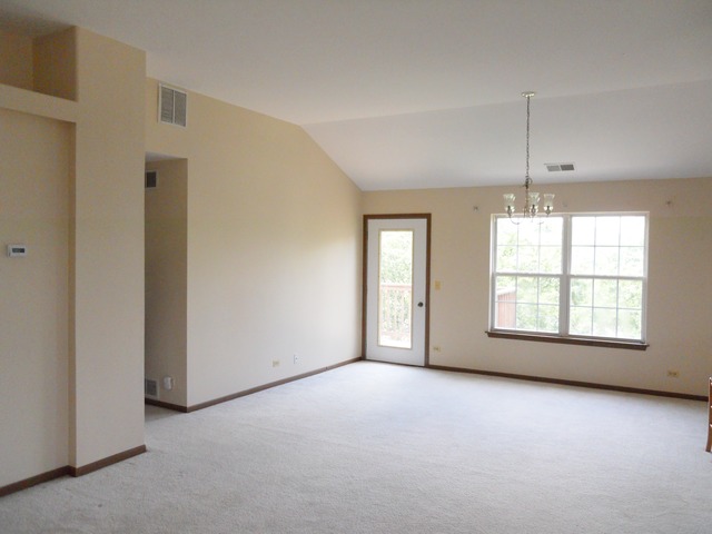 1303 Providence Circle, Unit 1303 Elgin, IL 60120 - Photo 4 of 16 an empty room with windows and chandelier
