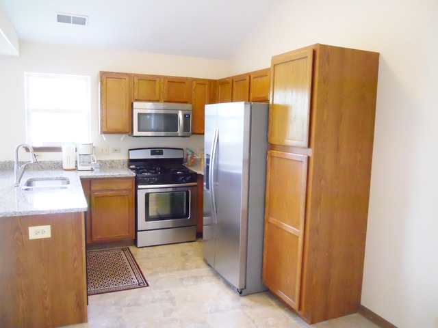 1303 Providence Circle, Unit 1303 Elgin, IL 60120 - Photo 8 of 16 a kitchen with a refrigerator and a sink