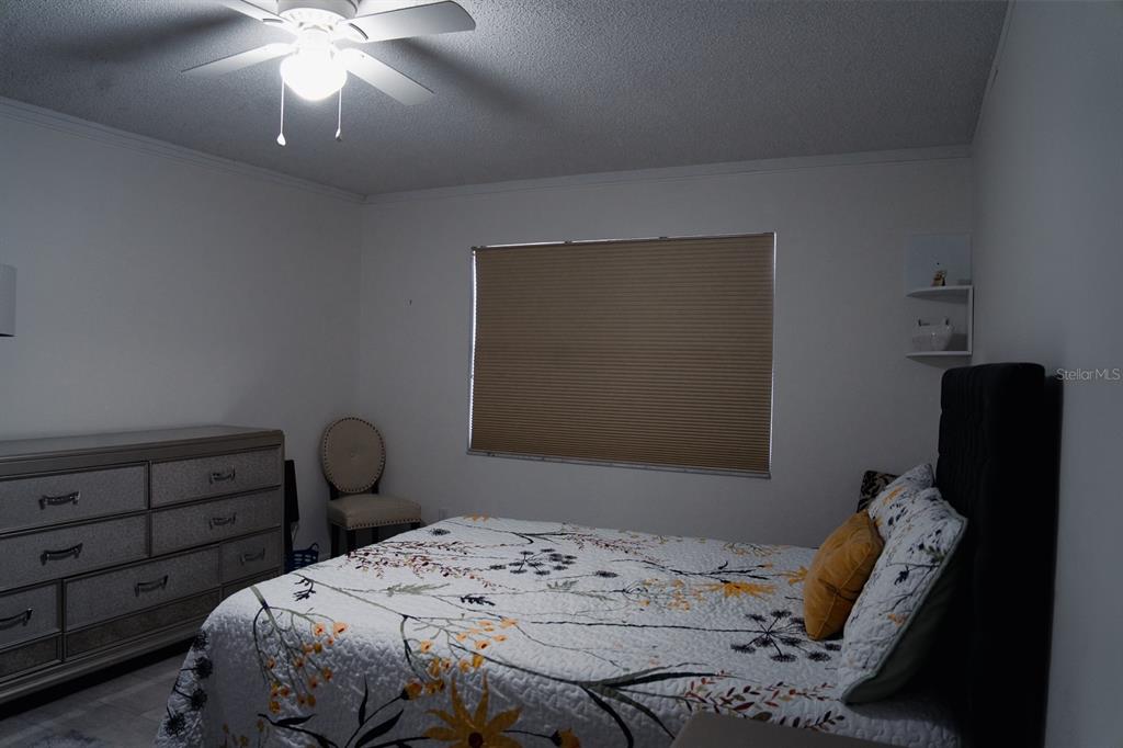 519 Albee Farm Road, Unit 110 Venice, FL 34285 - Photo 14 of 33 a bedroom with a bed and a chandelier