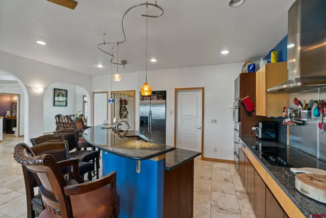 a kitchen with a stove a refrigerator and a living room view
