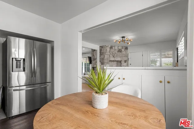 a kitchen with a refrigerator and a wooden floor