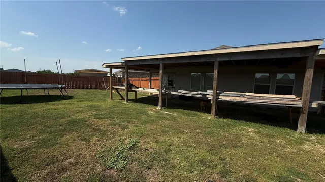 a backyard of a house with barbeque oven table and chairs