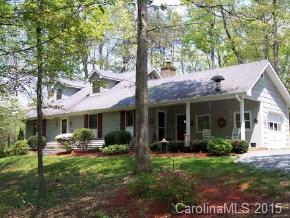 104 Hunters Trail Mill Spring Tryon, NC 28782 - Photo 1 of 4 a view of a house with table and chairs potted plants and a large tree