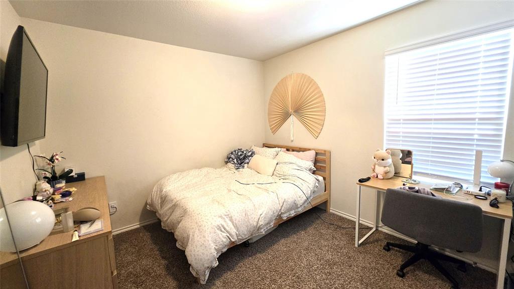 409 Samuel Street Denton, TX 76207 - Photo 8 of 40 a bed room with a bed and a chair