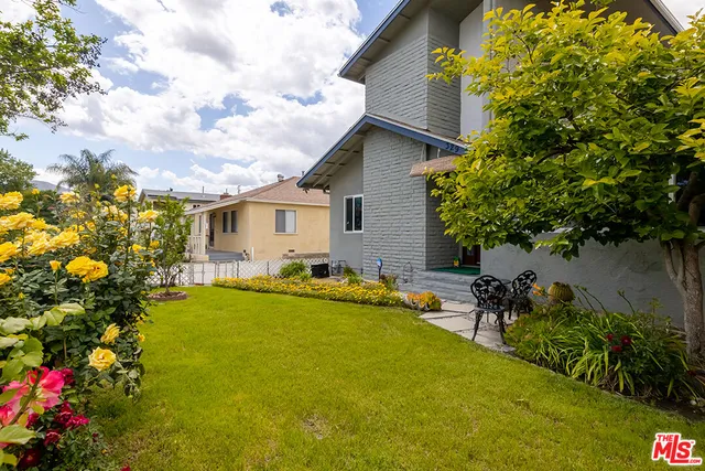 a view of a house with swimming pool lawn chairs and a yard