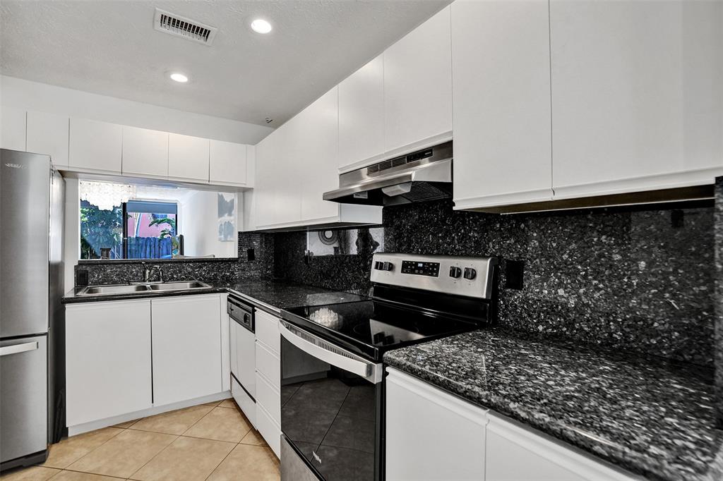 1415 Miami Road, Unit B Fort Lauderdale, FL 33316 - Photo 7 of 59 a kitchen with stainless steel appliances kitchen island granite countertop a stove and a sink