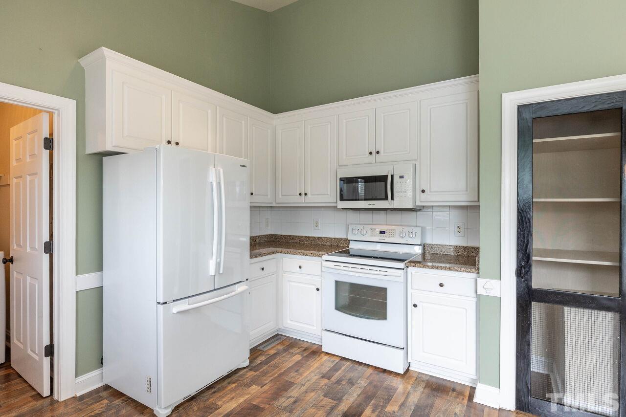 6573 Madison Road Bailey, NC 27807 - Photo 16 of 31 a kitchen with white cabinets and white appliances