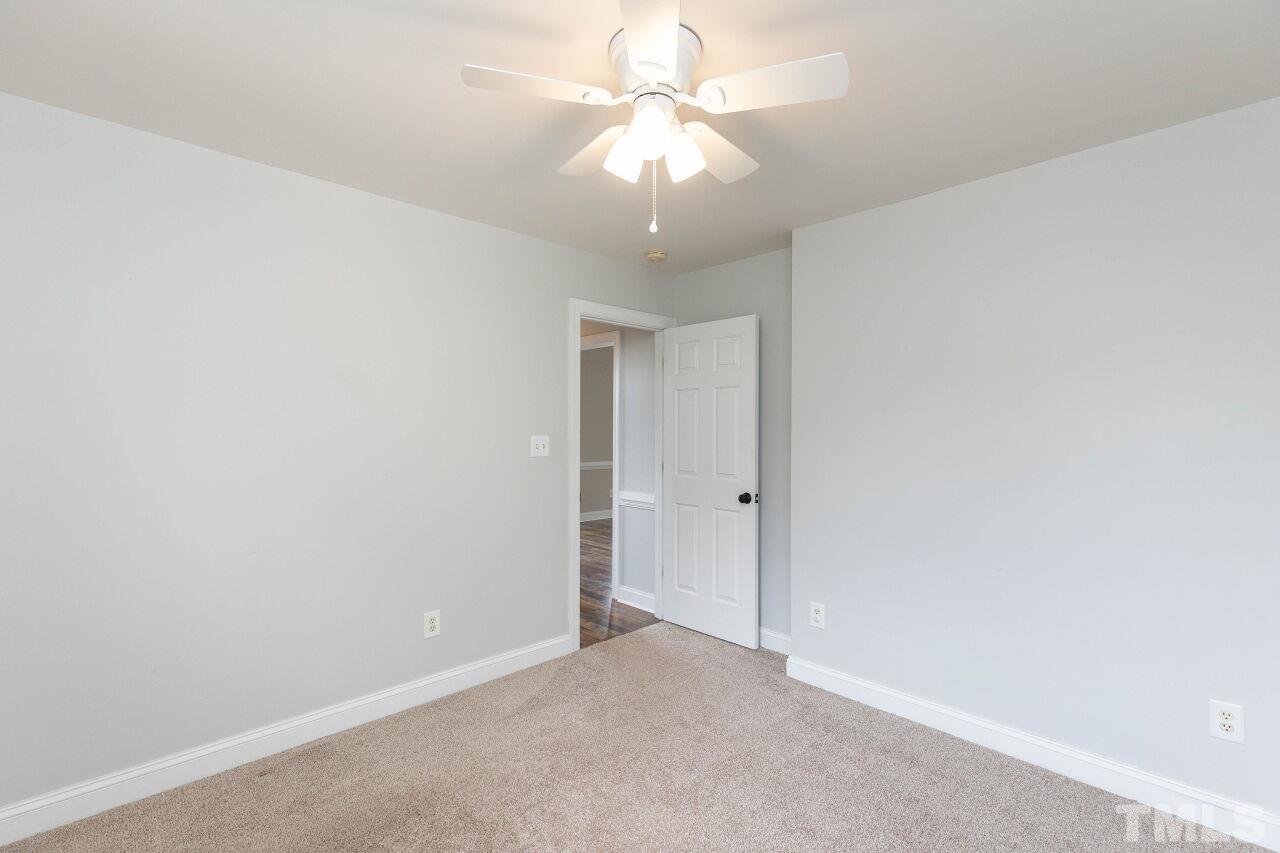 6573 Madison Road Bailey, NC 27807 - Photo 23 of 31 an empty room with a chandelier fan and closet