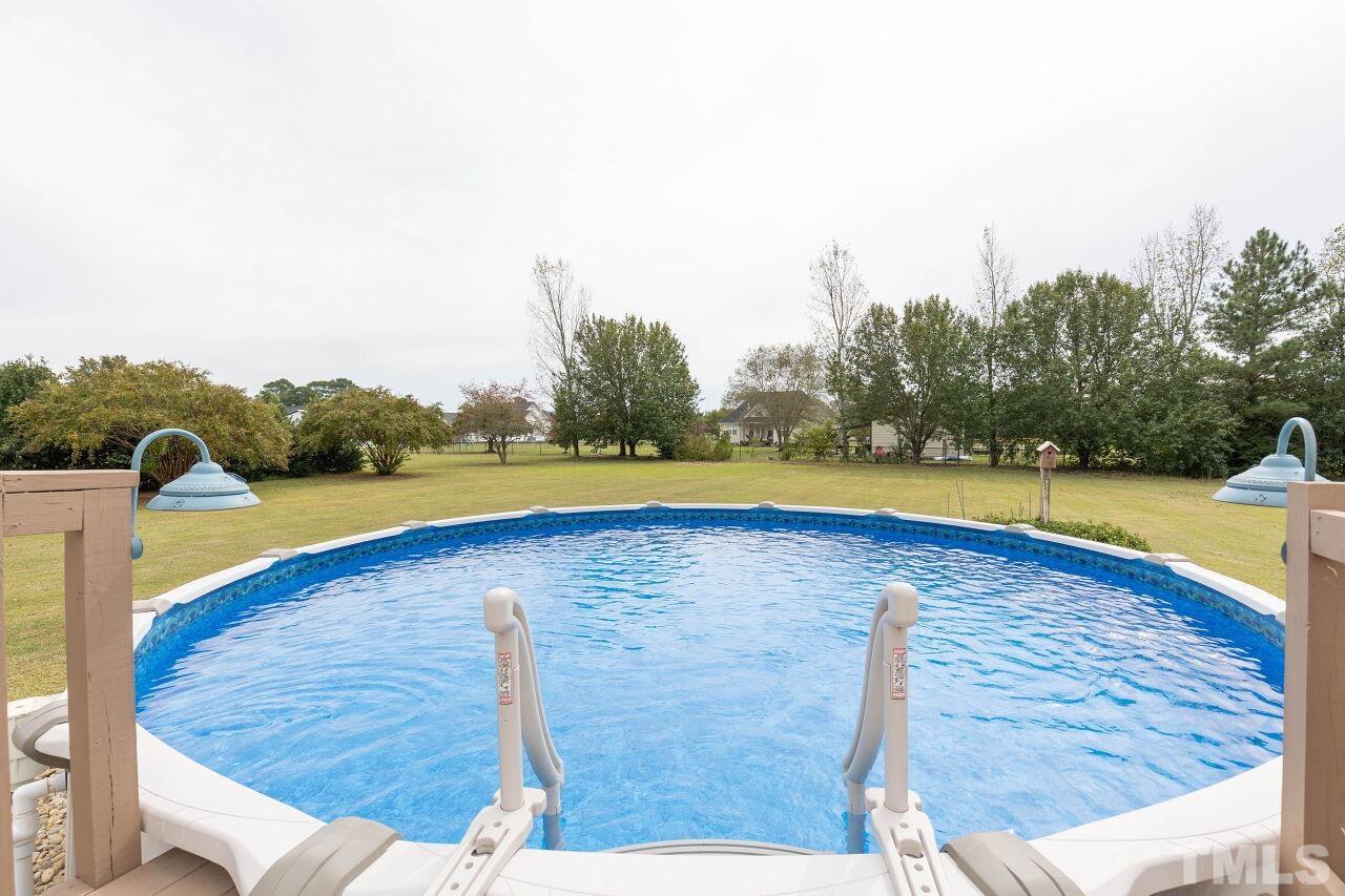 6573 Madison Road Bailey, NC 27807 - Photo 26 of 31 a view of a swimming pool with an outdoor seating and yard