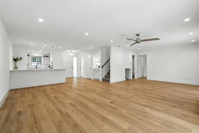 a view of an empty room and kitchen view