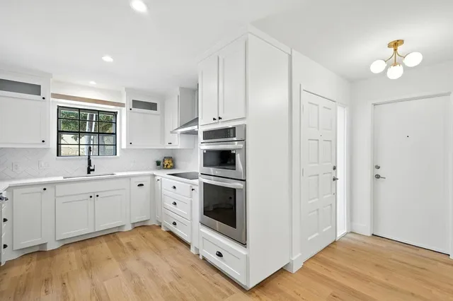 a kitchen with white cabinets and white appliances