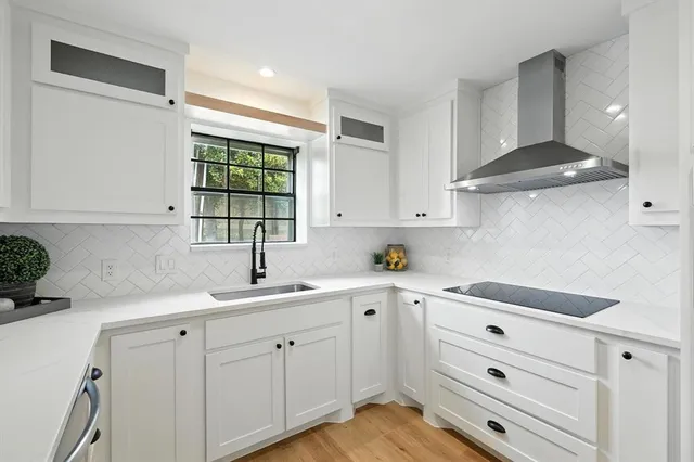 a kitchen with cabinets appliances a sink and a window