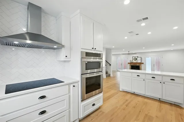 a kitchen with granite countertop white cabinets and stainless steel appliances
