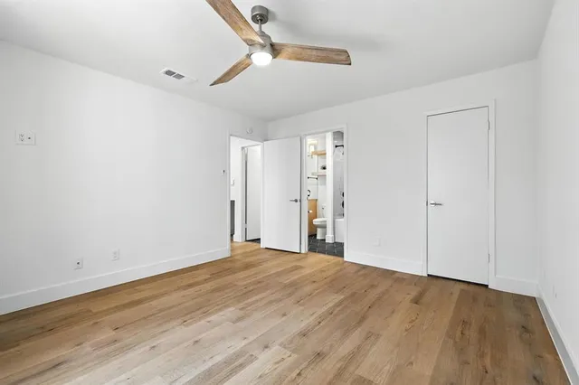 a view of an empty room with wooden floor