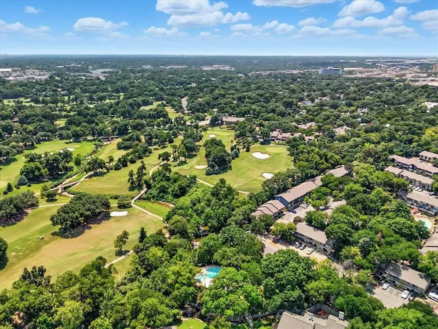 an aerial view of residential houses with outdoor space and trees