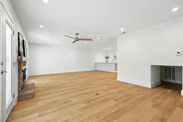 a view of empty room with wooden floor and window