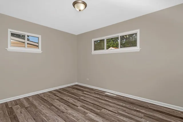 a view of a room with wooden floor and white walls