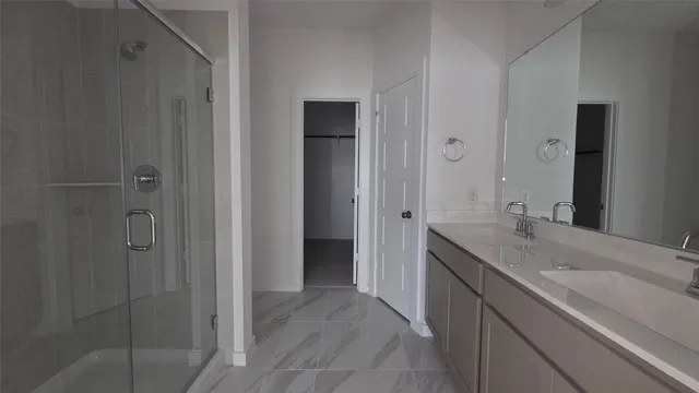 a spacious bathroom with a granite countertop sink a mirror and a shower