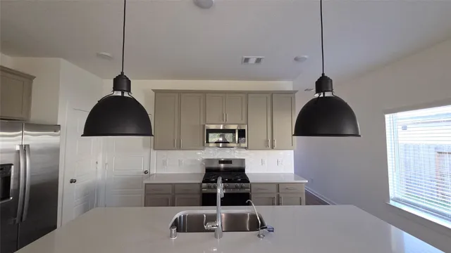 a kitchen with a sink a stove and refrigerator