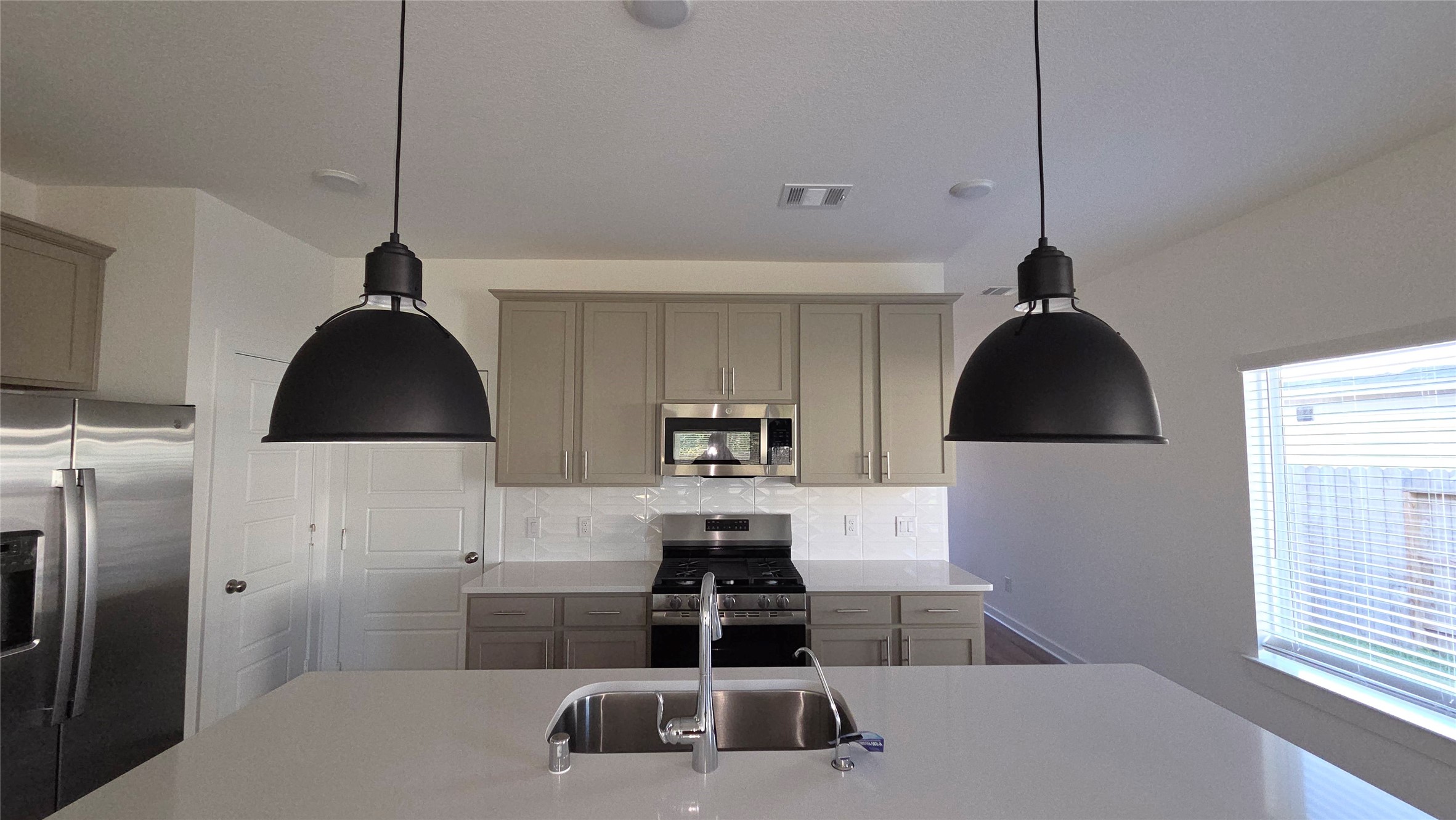 5847 Sunrise Btm Lane Fulshear, TX 77441 - Photo 7 of 21 a kitchen with a sink a stove and refrigerator