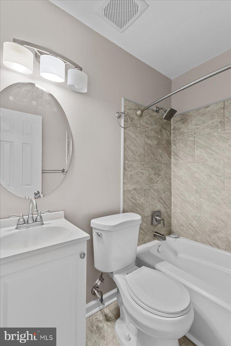 6812 Fulford Street Clinton, MD 20735 - Photo 17 of 32 a white toilet sitting next to a bathroom sink and a shower