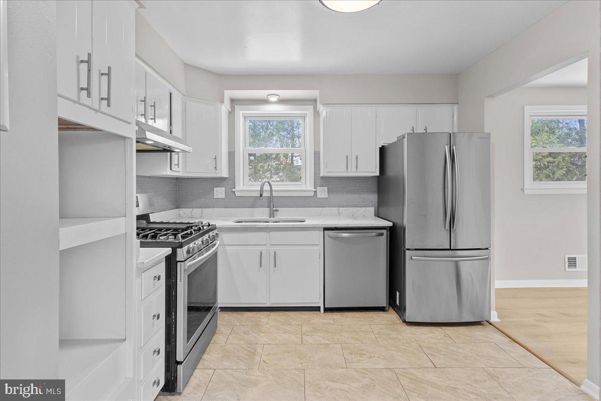 6812 Fulford Street Clinton, MD 20735 - Photo 10 of 32 a kitchen with stainless steel appliances granite countertop a refrigerator sink and stove
