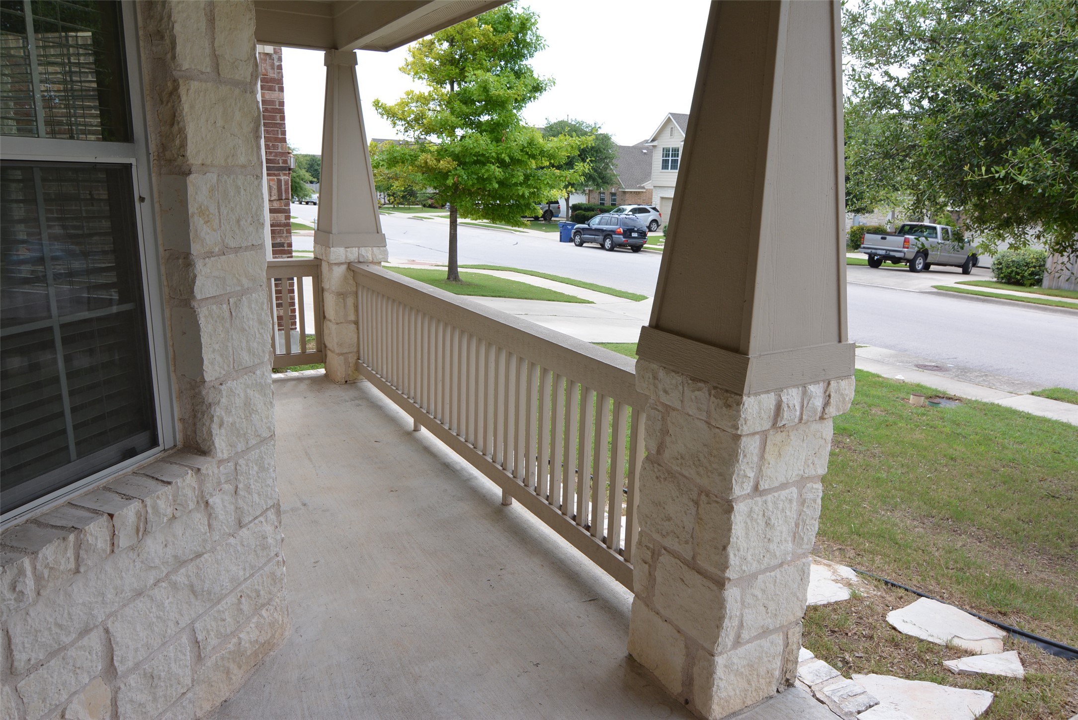 1303 Horseshoe Ranch Drive Leander, TX 78641 - Photo 4 of 26 A welcoming front porch with a sturdy stone and wood railing offers neighborhood views.