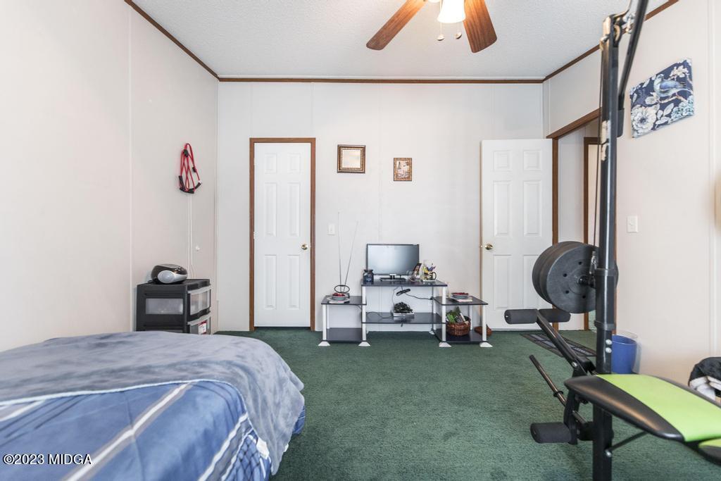 1592 Tribble Road Fort Valley, GA 31030 - Photo 11 of 30 a bedroom with bed and a chandelier