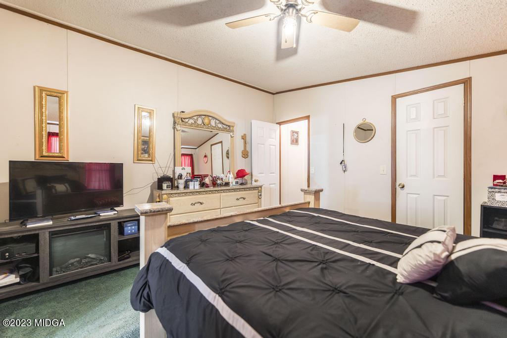 1592 Tribble Road Fort Valley, GA 31030 - Photo 15 of 30 a bedroom with a bed and a flat screen tv