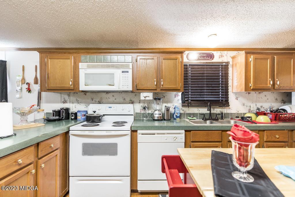 1592 Tribble Road Fort Valley, GA 31030 - Photo 24 of 30 a kitchen with a stove a sink and a microwave