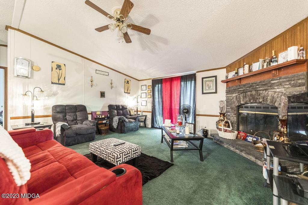 1592 Tribble Road Fort Valley, GA 31030 - Photo 29 of 30 a living room with furniture a fireplace and a flat screen tv