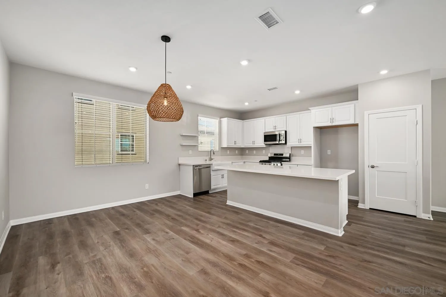 1515 Fig Tree Way Oceanside, CA 92056 - Photo 10 of 27 a open kitchen with white cabinets and wooden floor