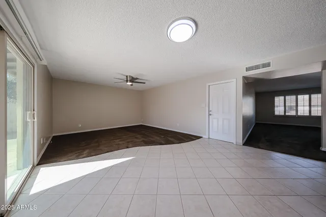an empty room with fan and windows