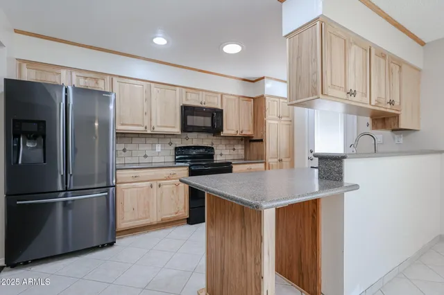 a kitchen with stainless steel appliances granite countertop a refrigerator a sink a stove a microwave and island