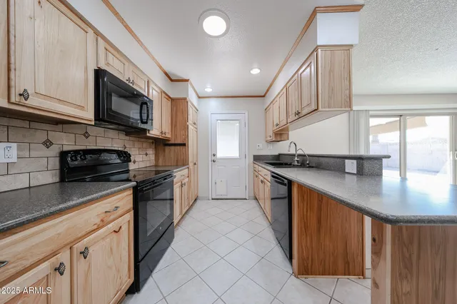 a kitchen with stainless steel appliances granite countertop a stove a sink and a microwave