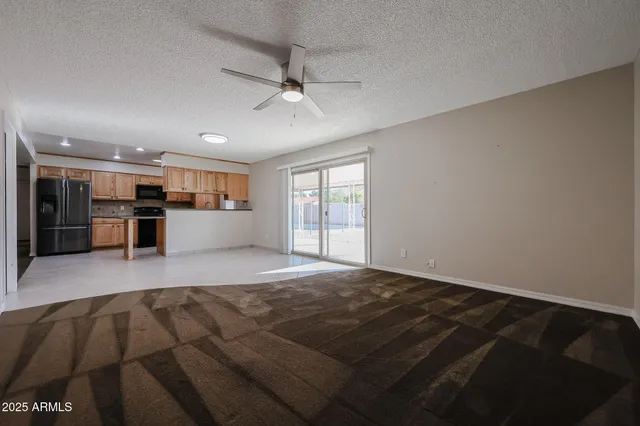 an empty room with fan and windows